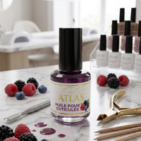 Flacon d'huile pour cuticules ATLAS parfum Fruits des Bois 15ml, illustré avec des framboises et mûres, posé sur une table de travail en marbre dans un institut d'onglerie